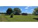 Expansive property featuring a single-story home with a detached building, set against a backdrop of mature trees at 14721 Highway 36, Covington, GA 30014