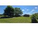 Expansive property featuring a single-story home with a detached building, set against a backdrop of mature trees at 14721 Highway 36, Covington, GA 30014