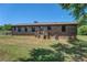 Backyard of the brick home with lawn, deck, and mature tree at 14721 Highway 36, Covington, GA 30014