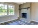 Close-up of the gray brick fireplace in the living room with vinyl floors and a large window at 14721 Highway 36, Covington, GA 30014