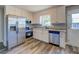 Well-lit kitchen boasts new stainless appliances, white cabinets, and a garden window at 14721 Highway 36, Covington, GA 30014