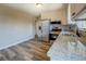 A kitchen features stainless steel appliances, granite countertops, white cabinets, and wood-look flooring at 14721 Highway 36, Covington, GA 30014