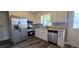 A kitchen featuring stainless steel appliances, white cabinets, and wood-look flooring at 14721 Highway 36, Covington, GA 30014