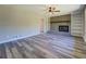 Bright living room featuring a brick fireplace, mantle, built-in shelving and wood-look flooring at 14721 Highway 36, Covington, GA 30014