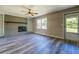 Living room features a brick fireplace, mantle, built-in shelving, wood-look flooring and plenty of natural light at 14721 Highway 36, Covington, GA 30014