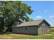 This is an outbuilding shed, with a grey tone and surrounded by a large tree at 14721 Highway 36, Covington, GA 30014