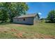 This is an outbuilding shed, with a grey tone and surrounded by grassy terrain at 14721 Highway 36, Covington, GA 30014