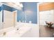 Bathroom with blue accent wall, a white vanity and fixtures and a view to the Dining Room at 2114 Woodland Ln, Alpharetta, GA 30009