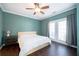 Well-lit bedroom features a ceiling fan, dark floors and french doors to a balcony at 2114 Woodland Ln, Alpharetta, GA 30009