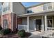 Charming entrance with a covered porch, featuring brick accents and a freshly painted front door, inviting guests inside at 2114 Woodland Ln, Alpharetta, GA 30009