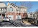Two-story townhome featuring a two-car garage, brick accents, and well-maintained landscaping, providing a cozy curb appeal at 2114 Woodland Ln, Alpharetta, GA 30009