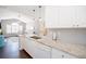 Stylish kitchen with granite countertops, white cabinets, and a view of the living room, seamlessly blending functionality and design at 2114 Woodland Ln, Alpharetta, GA 30009