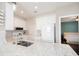 Well-lit kitchen features granite countertops, white cabinetry and appliances, offering plenty of space to create delicious meals at 2114 Woodland Ln, Alpharetta, GA 30009