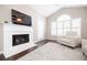 Cozy living room with a fireplace, vaulted ceiling, and ample natural light creating a warm and inviting atmosphere at 2114 Woodland Ln, Alpharetta, GA 30009