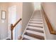 Elegant staircase with hardwood treads, white risers, and a stained wood handrail, leading to the upper level at 2114 Woodland Ln, Alpharetta, GA 30009