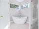 Spa bathroom features a soaking tub under a window and a walk-in shower with glass door at 255 Northland Ridge Trl, Atlanta, GA 30342