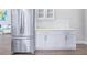 Modern kitchen area with stainless steel refrigerator and white cabinets, seamlessly connecting to the living room at 255 Northland Ridge Trl, Atlanta, GA 30342