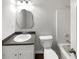 Bright bathroom with a modern sink, toilet, and bathtub/shower combo with a unique mirror at 3766 Windy Hill Se Dr, Conyers, GA 30013