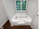 Bathroom featuring a large white garden tub under a window, perfect for relaxation at 3766 Windy Hill Se Dr, Conyers, GA 30013