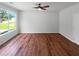 Bright living room featuring hardwood floors, a ceiling fan, and a large window with a view of the outdoors at 3766 Windy Hill Se Dr, Conyers, GA 30013