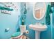 Bright bathroom with blue walls, pedestal sink, and decorative accents at 6664 Saint Jude Dr, Fairburn, GA 30213