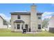 Back exterior view of this home highlighting a patio and backyard and complemented by neutral-colored siding and a chimney at 6664 Saint Jude Dr, Fairburn, GA 30213