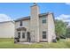Back exterior view of this home highlighting a patio and backyard and complemented by neutral-colored siding and a chimney at 6664 Saint Jude Dr, Fairburn, GA 30213