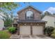 Exterior shot of a home with a brick front, a two-car garage, and lush landscaping at 6664 Saint Jude Dr, Fairburn, GA 30213