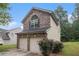 View of the home's exterior featuring a two-car garage and attractive brick accents at 6664 Saint Jude Dr, Fairburn, GA 30213