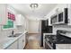 Modern kitchen with stainless steel appliances, gas range, granite counters, and adjacent dining area at 100 Davis Mill N Rd, Dallas, GA 30157