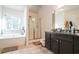 Bright bathroom features a soaking tub, walk-in shower, and dark wood vanity with granite countertop at 2496 Osceola Rd, Lithonia, GA 30058