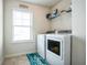 Efficient laundry room with side-by-side washer and dryer and a storage shelf above at 2496 Osceola Rd, Lithonia, GA 30058