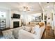 Cozy living room featuring a fireplace, ceiling fan, and open access to the kitchen at 2496 Osceola Rd, Lithonia, GA 30058