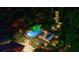 Aerial view of a backyard with a pool and seating area surrounded by trees and illuminated pathways at 3117 W Roxboro Ne Rd, Atlanta, GA 30324