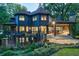 A two-story home with a deck and a stone patio, surrounded by lush flowers and landscaping at 3117 W Roxboro Ne Rd, Atlanta, GA 30324