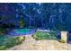 A backyard pool surrounded by lush greenery, stone steps and patio, and mature trees at dusk at 3117 W Roxboro Ne Rd, Atlanta, GA 30324