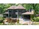 A spacious backyard featuring a two-story home with a deck, outdoor seating area, stone patio, and lush landscaping at 3117 W Roxboro Ne Rd, Atlanta, GA 30324