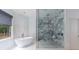 Modern bathroom with soaking tub, separate glass shower and white marble accents at 3117 W Roxboro Ne Rd, Atlanta, GA 30324