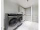 Bright laundry room features front-loading washer and dryer and sleek white cabinetry at 3117 W Roxboro Ne Rd, Atlanta, GA 30324