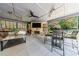 Outdoor living space with a fireplace, kitchen, and seating area overlooking the backyard at 3117 W Roxboro Ne Rd, Atlanta, GA 30324