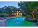 Backyard pool with a spa, surrounded by a stone patio, lush trees, and landscaping at 3117 W Roxboro Ne Rd, Atlanta, GA 30324