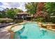 Backyard pool with a spa, surrounded by a stone patio, lush trees, and landscaping at 3117 W Roxboro Ne Rd, Atlanta, GA 30324