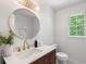 Bright bathroom with a modern vanity, round mirror, gold faucet and large window at 3214 Woodleaf Ct, Marietta, GA 30062
