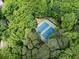 Aerial view of two blue tennis courts surrounded by lush green trees, providing a private and scenic playing environment at 3214 Woodleaf Ct, Marietta, GA 30062
