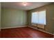 Bedroom featuring hardwood floors, neutral green walls and a large window at 4048 Emerald Lake Dr, Decatur, GA 30035