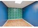 Bright basement room with unique leaf-patterned accent wall and laminate flooring at 610 Golden Meadows Ln, Suwanee, GA 30024