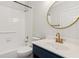 Bathroom features white tile, a tub, and a navy blue vanity with a gold faucet at 610 Golden Meadows Ln, Suwanee, GA 30024