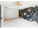 Spacious bedroom featuring plush carpeting, a ceiling fan and an accent wall with floral wallpaper at 610 Golden Meadows Ln, Suwanee, GA 30024