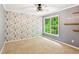Unique bedroom features themed wallpaper, wood shelving, and a bright window at 610 Golden Meadows Ln, Suwanee, GA 30024