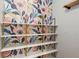 Closet featuring custom floral wallpaper, gold hardware and white shelves at 610 Golden Meadows Ln, Suwanee, GA 30024